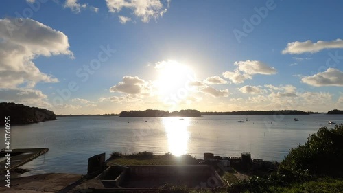 calm and relaxing sunset over the sea and islands with blue sky, clouds, some boats, landscape in France