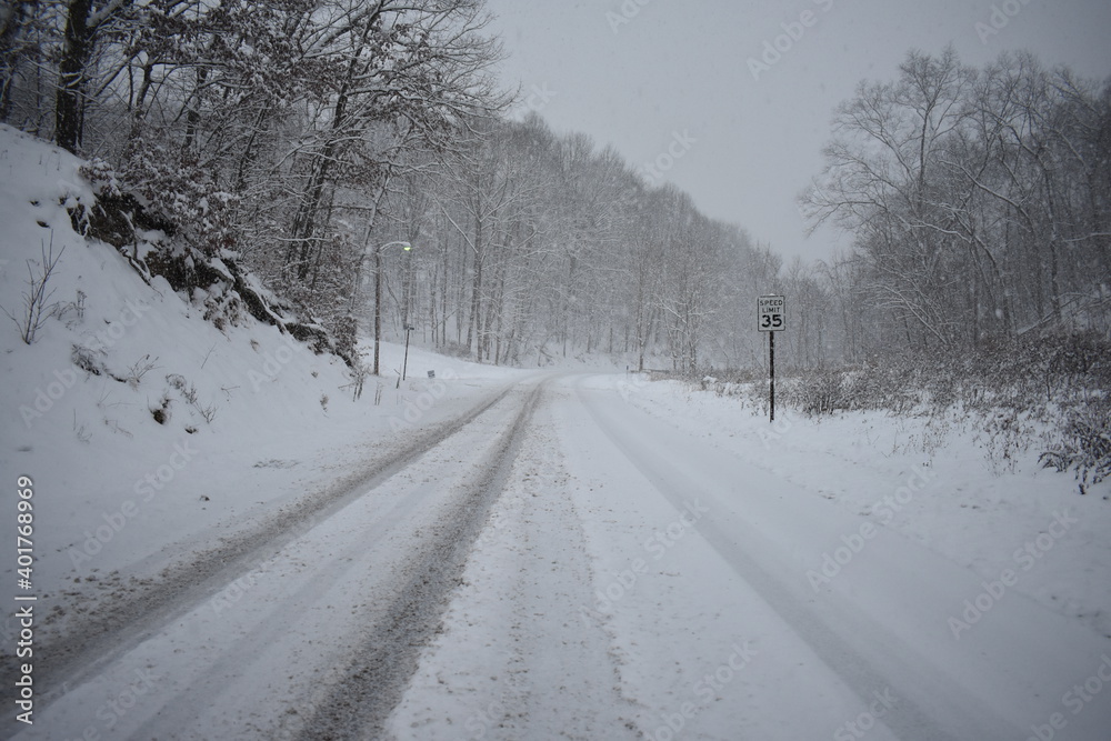 Fresh snow covered rural country road with trees and speed limit sign Fresh snow covered rural country road with trees and speed limit sign