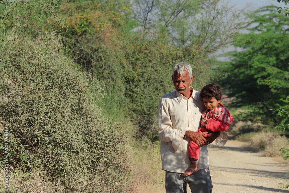 A grandfather living in rural areas of India raising his grandson in the womb while walking