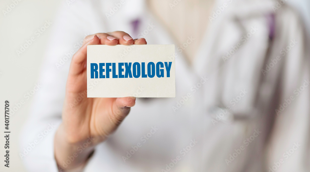 REFLEXOLOGY. Card with text in hand of Medical Doctor. REFLEXOLOGY. Card with text in hand of Medical Doctor.