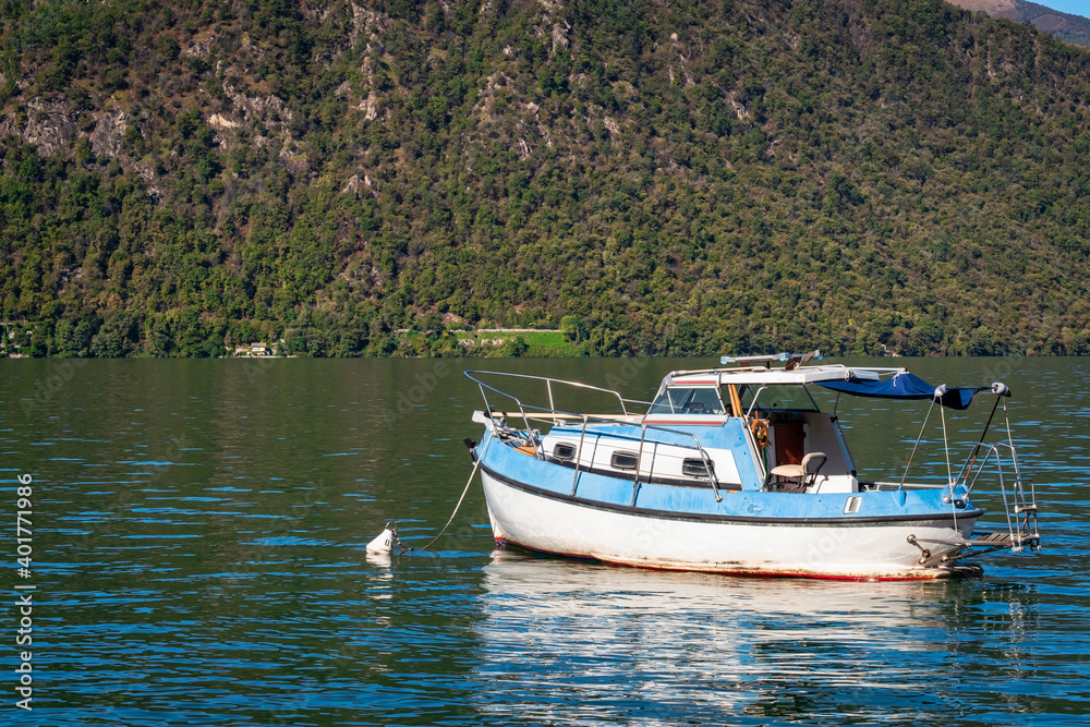 Leisure boat, moored in the Orta Lake (piedmont, Northern Italy) seen from the city of Orta, along the lake shores during early fall season. UNESCO World Heritage Site.