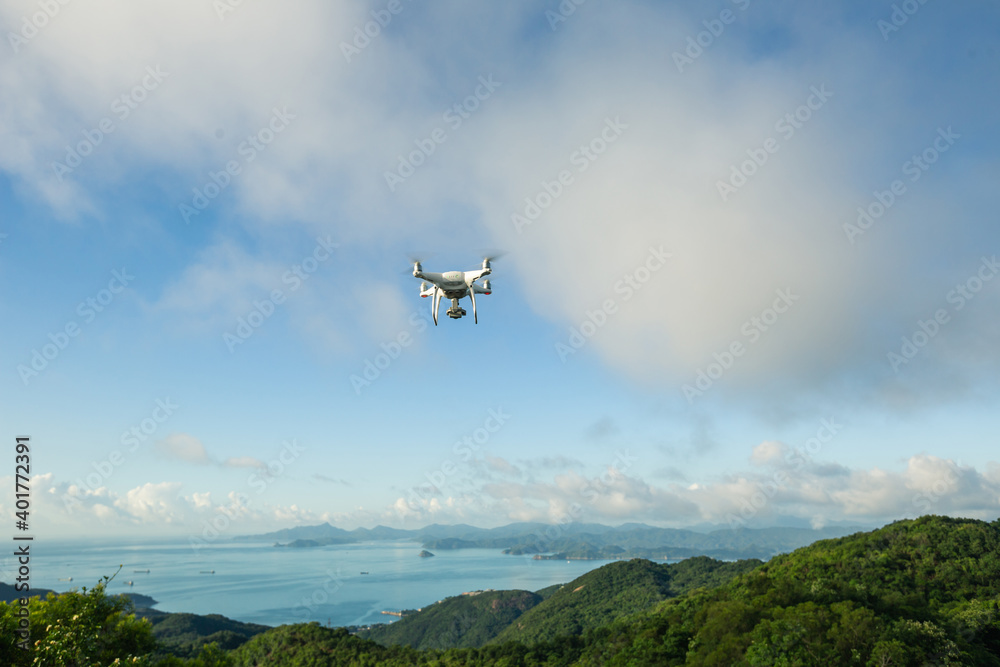 Flying drone taking photo of landscape with sea and mountains