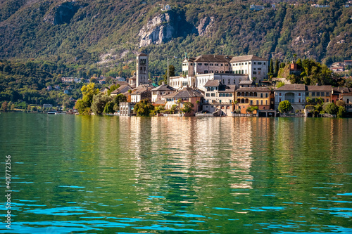 The world famous Orta San Giulio island, in the Orta Lake (Piedmont, Northern Italy) seen from the city of Orta, along the lake shores. It is UNESCO World Heritage Site. photo