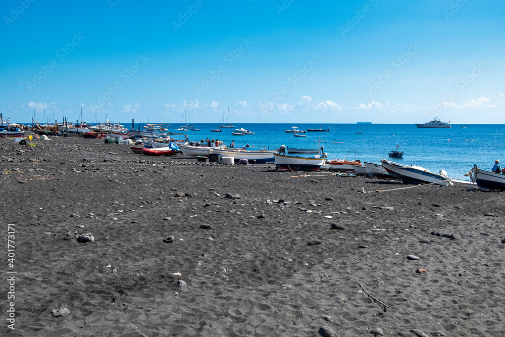View of the black sand beach of the Vulcano Island, small volcanic island, located in the Mediterranean Sea, between Sicily and Calabria Regions (Southern Italy), with it turquoise clear waters.