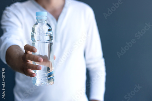 Close-up of man holding bottle of water.