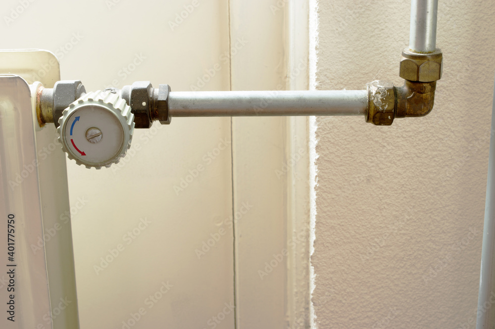 Grey knob of a heating radiator with pipe at home Grey knob of a heating radiator with pipe at home