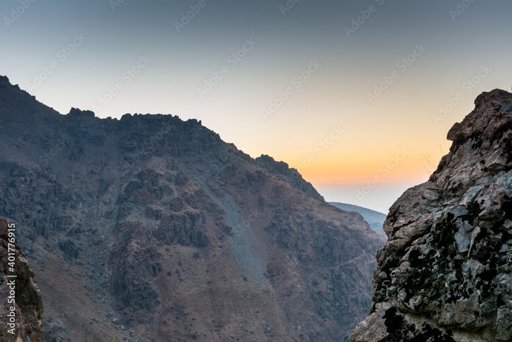 Barren mountain in Darband valley in dawn against colorful sky in the Tochal mountain with background of Tehran city in the morning. A popular recreational region for Tehran's residents
