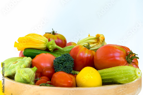 Wooden plate with fresh vegetables - tomatoes  zucchini  broccoli  and squash