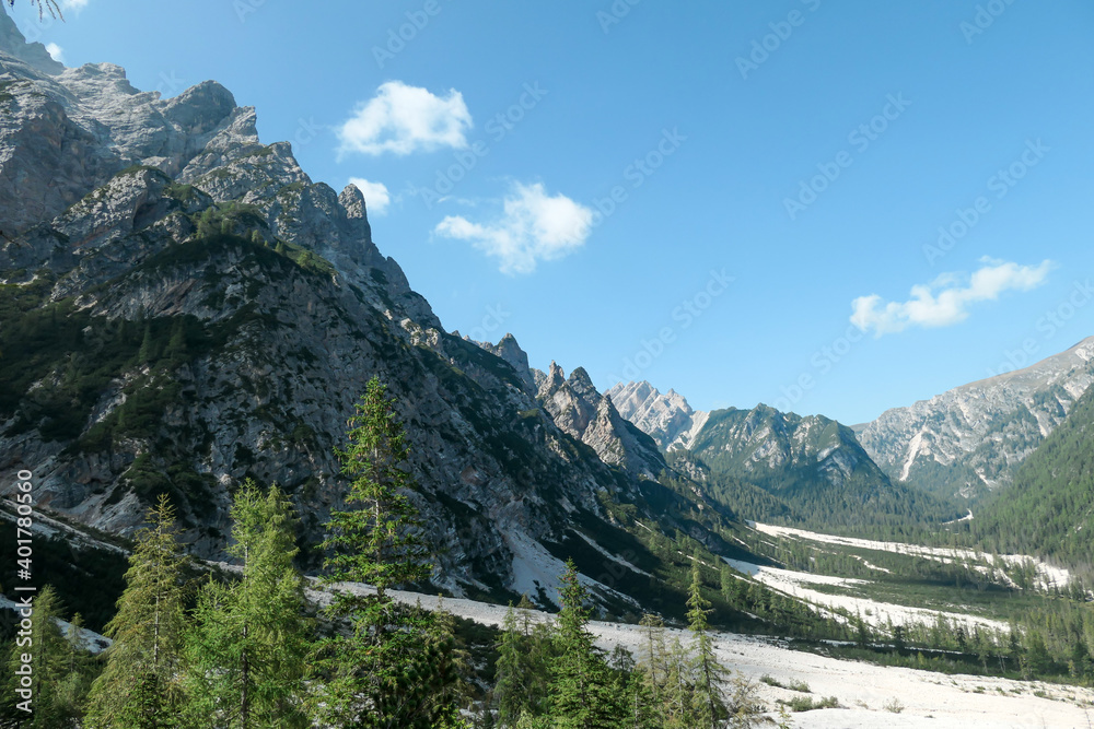 A massive landslide area in Italian Dolomites. The whole area is full of small stones and pebbles. In the back there are high and sharp mountain chains. Raw and desolated area. Few trees on the slopes A massive landslide area in Italian Dolomites. The whole area is full of small stones and pebbles. In the back there are high and sharp mountain chains. Raw and desolated area. Few trees on the slopes