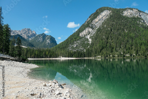 A panoramic view on the Pragser Wildsee, a lake in South Tyrolean Dolomites. High mountain chains around the lake. The sky and mountains are reflecting in the lake. Dense forest at the shore. Serenity © Chris