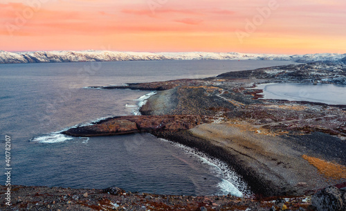 A rock cliff with a tidal shoreline. Wonderful panoramic mountain landscape on the Barents sea. Teriberka.