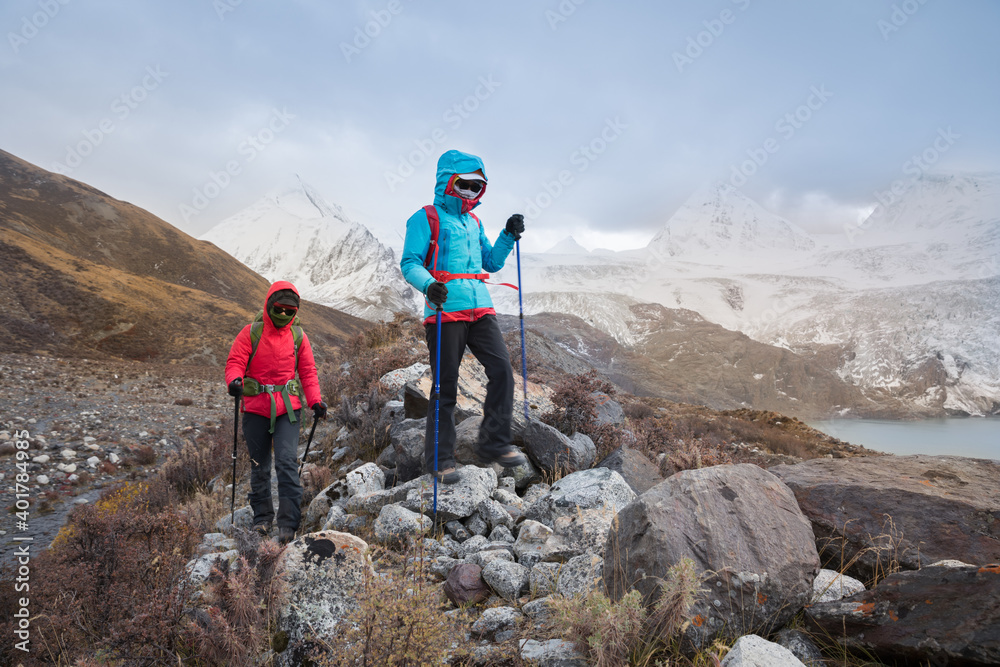 Fototapeta premium Two women hikers hiking in winter mountains