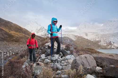 Two women hikers hiking in winter mountains