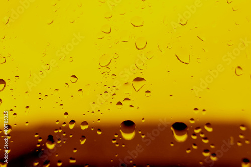 Yellow background with water drops on the glass. The heel is design for beer. Close-up