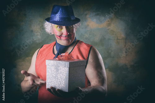 Slika na platnu The clown holds a gift box in his hands