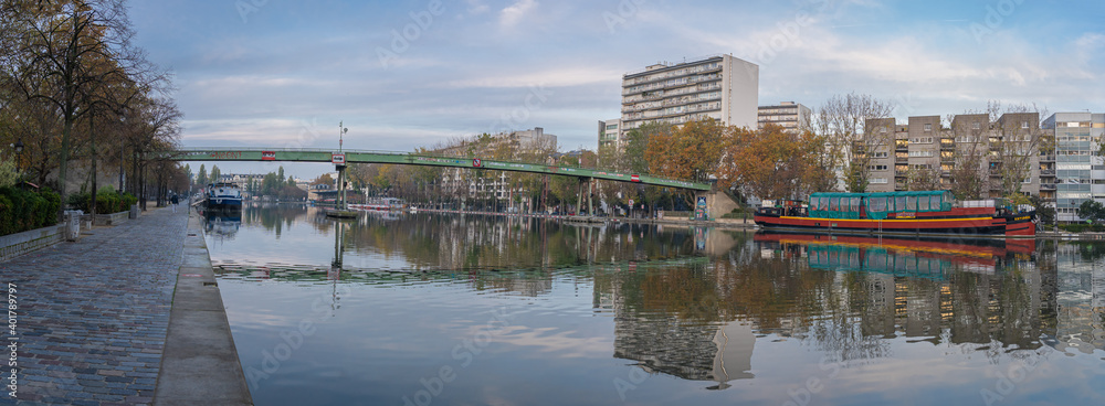 Paris, France - 11 07 2020: Reflections on the Ourcq canal of the Villette basin footbridge