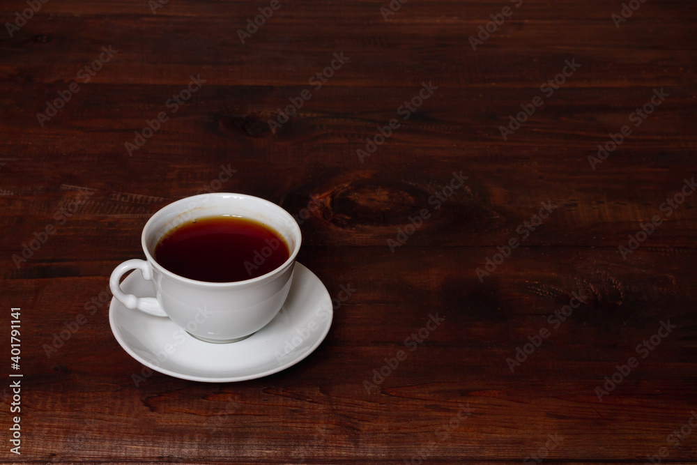 A white Cup of tea on a brown wooden table. Copy space. A white Cup of tea on a brown wooden table. Copy space.