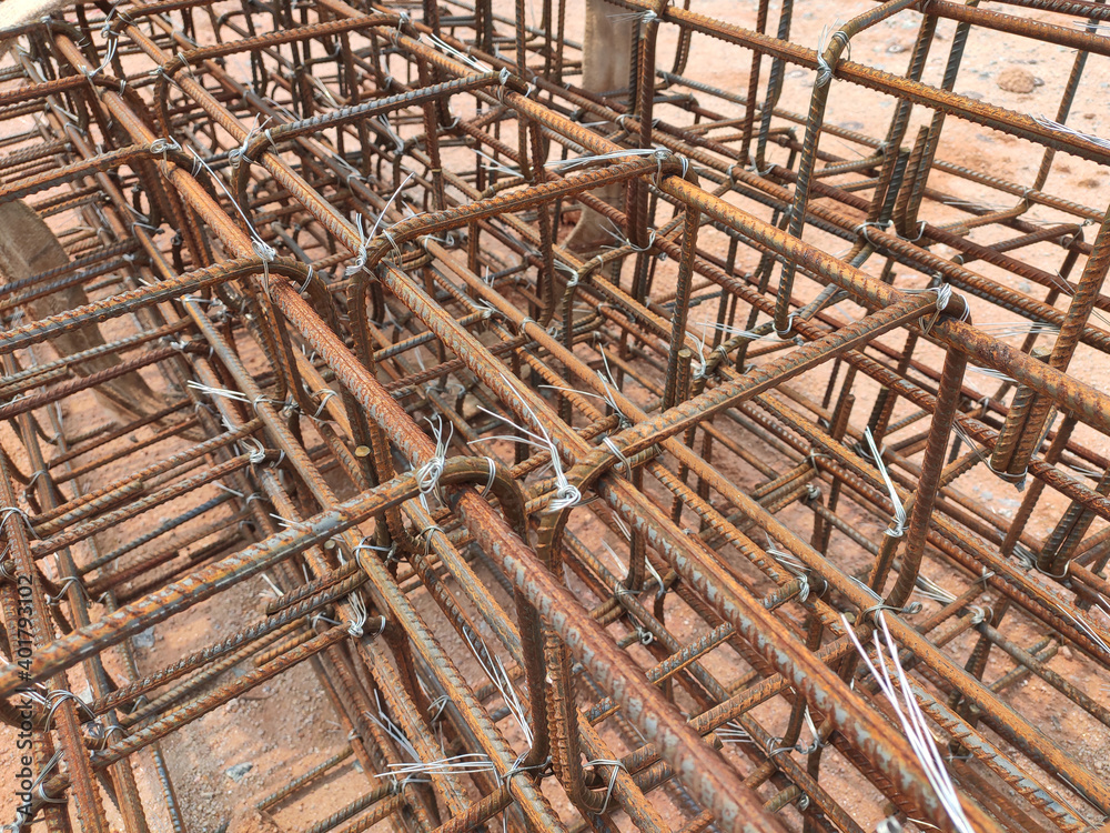 SEREMBAN, MALAYSIA -MARCH 29, 2020: Construction workers fabricating steel reinforcement bar at the construction site. They tied it together using the tiny wires before cover it up using formworks. 