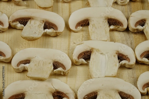 Champignon slices lie on a wooden kitchen table, background