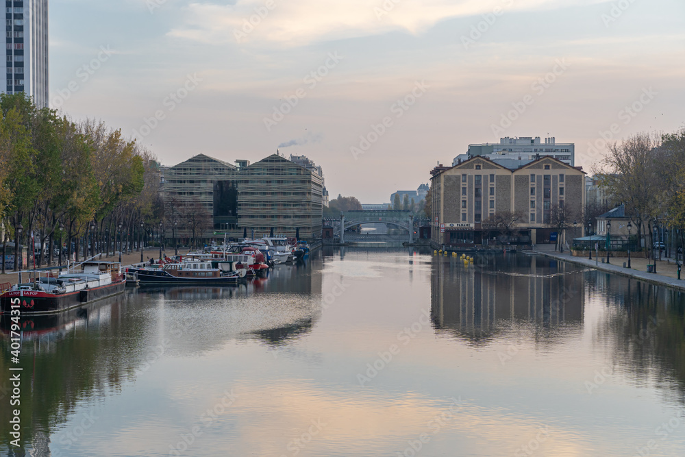 Paris, France - 11 07 2020: Reflections on the Ourcq canal of the lift bridge at sunrise