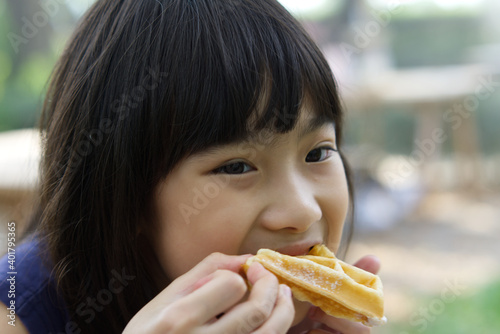 Portrait Asian cute child girl 7 years old Eat Waffles