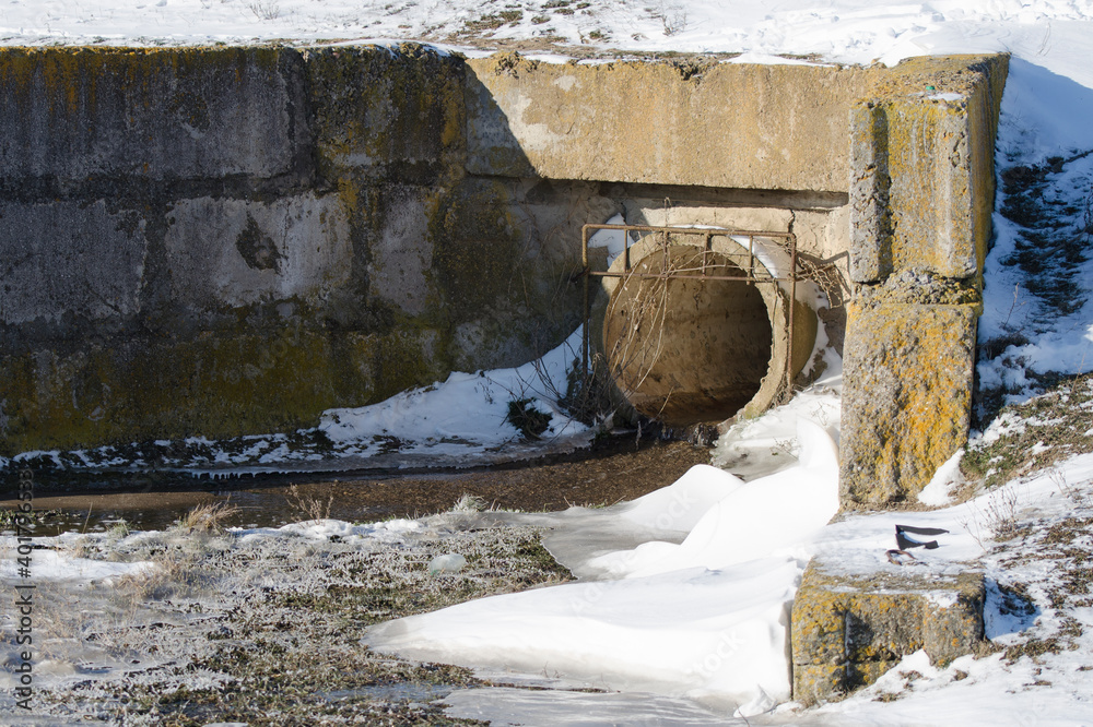 Draining drainage water through a sewer pipe. Melting snow in spring. Draining drainage water through a sewer pipe. Melting snow in spring.