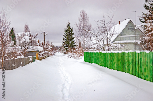 Real Russian winter, when frost and a lot of snow, in the country village, with small houses, roads through high snowdrifts