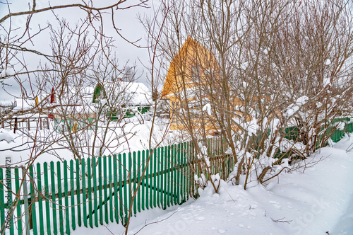 Real Russian winter, when frost and a lot of snow, in the country village, with small houses, roads through high snowdrifts