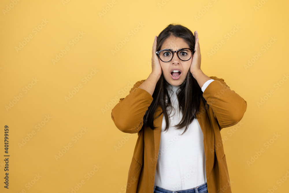 Young beautiful woman wearing a blazer over isolated yellow background suffering from headache desperate and stressed because pain and migraine with her hands on head