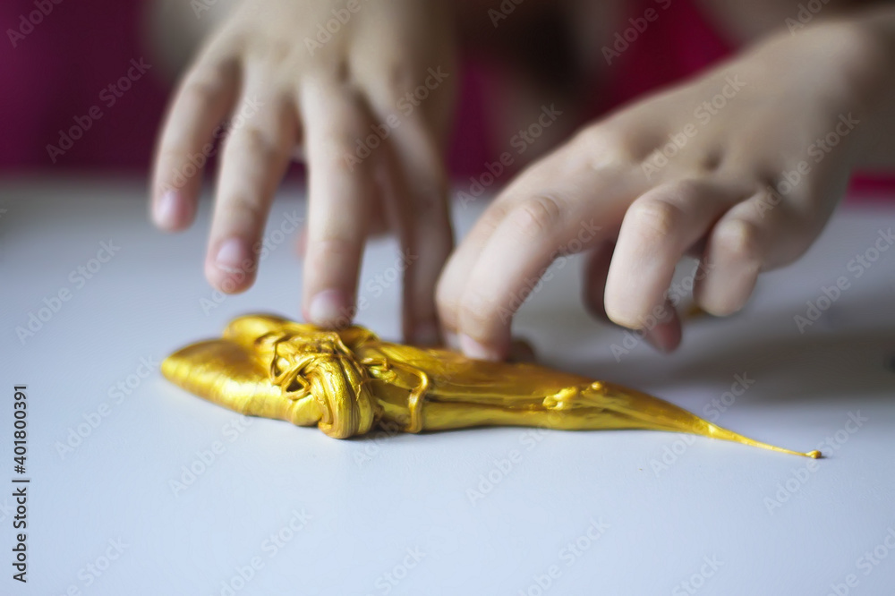 Obraz premium Child playing with a gold slime