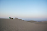 buggy de arena con la gente admirando las extensas dunas de arena que acaban de recorrer al atardecer con el cielo pintado de colores