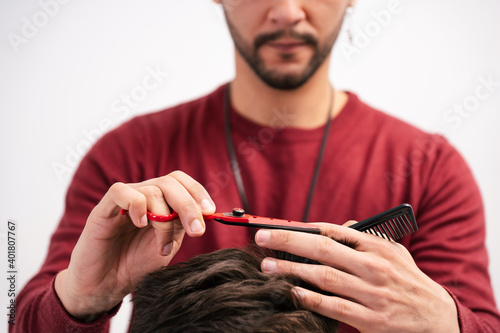man cutting hair on white background