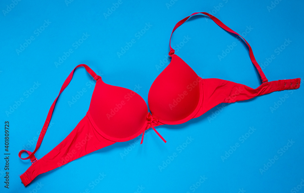 Bright red bra on a blue background. copy space. top view Bright red bra on a blue background. copy space. top view