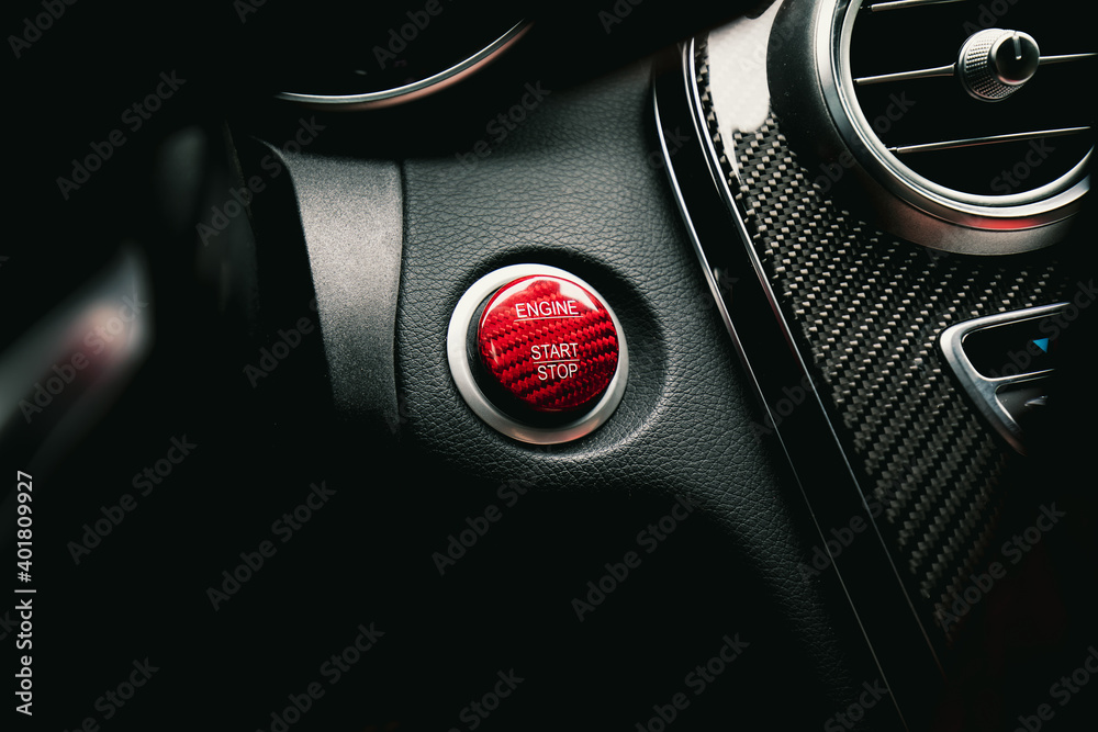 Close up view of red engine start and stop button in a high end sports car 