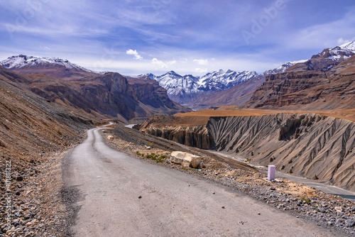 View from hilly mountain road  travelling to Chandrataal Lake through gully eroded geological landform prominent in cold desert of Spiti valley due to barren steep slopes and weak geological mud rocks photo