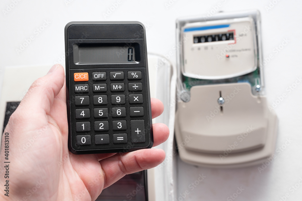 Calculator and electric meter on the wall. Calculation of electricity costs concept. Calculator and electric meter on the wall. Calculation of electricity costs concept.