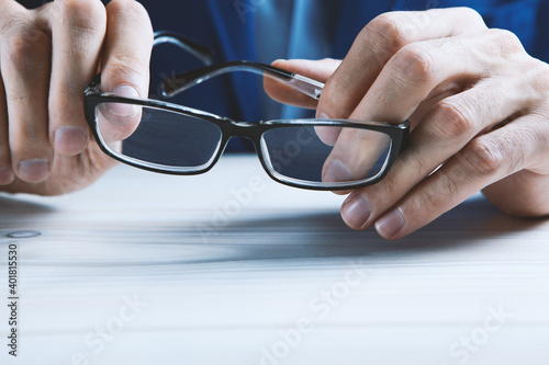 man holds glasses in his hands.