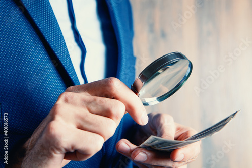 businessman holding a magnifying glass and wallet