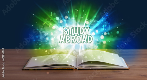 STUDY ABROAD inscription coming out from an open book, educational concept