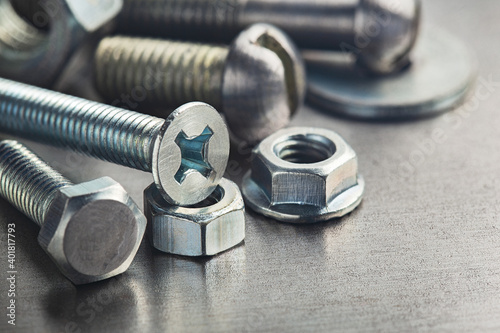 nuts, bolts, screws, washers, bearings on a metal steel background. photo