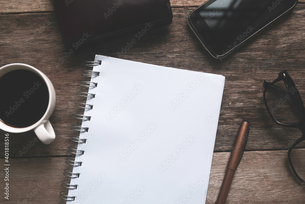 Business and finance concept.Top view of a cup of coffee,wallet,mobile phone,pen and notebook on wooden table. Business and finance concept.Top view of a cup of coffee,wallet,mobile phone,pen and notebook on wooden table.