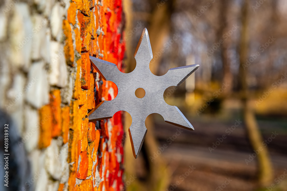 Shuriken (throwing star), traditional japanese ninja cold weapon stuck in wooden background