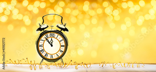 Unscharfer Goldener Silvesterhintergrund mit 2021 Wecker