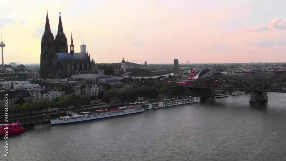 Aerial view of the Cologne Cathedral, the Rhine river and the Hohenzollern Bridge, colorful dusk sky, in Koln, Germany - dolly, drone shot Aerial view of the Cologne Cathedral, the Rhine river and the Hohenzollern Bridge, colorful dusk sky, in Koln, Germany - dolly, drone shot