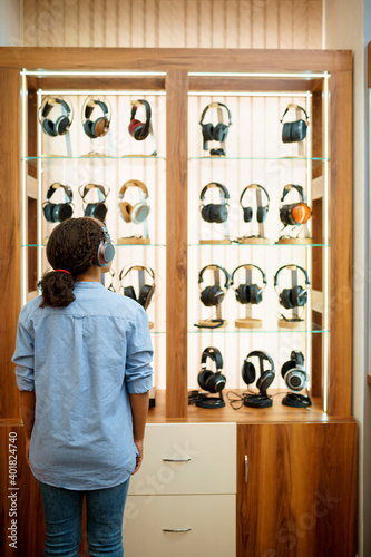 Woman choosing headphones in acoustics store