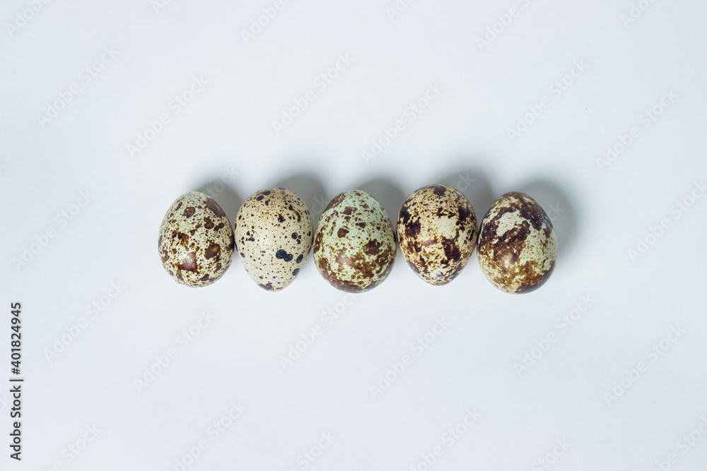 Quail eggs on a white background. Healthy eating. Quail eggs lie in a row