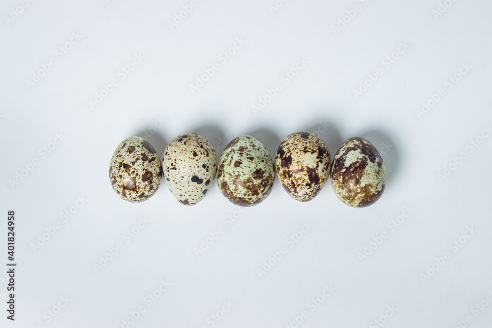 Quail eggs on a white background. Healthy eating. Quail eggs lie in a row