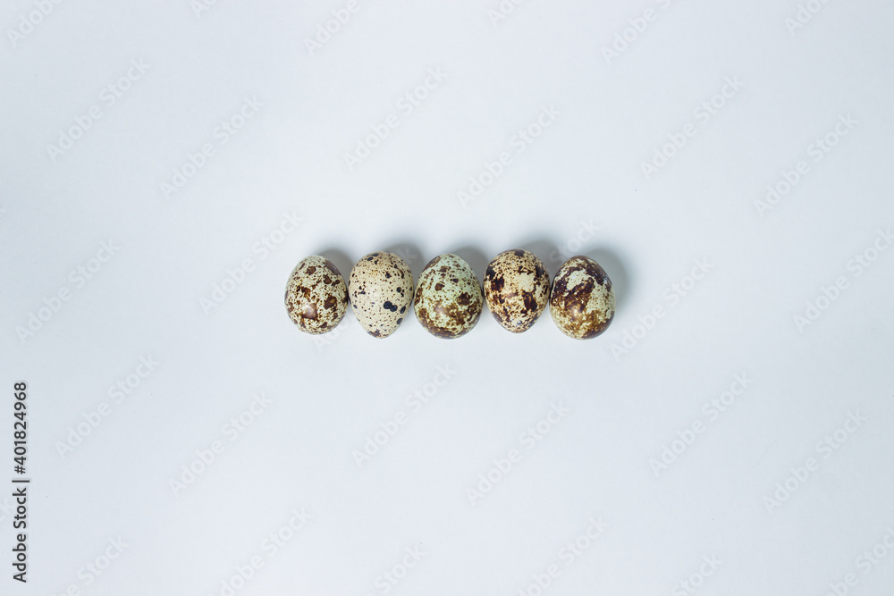 Quail eggs on a white background. Healthy eating. Quail eggs lie in a row