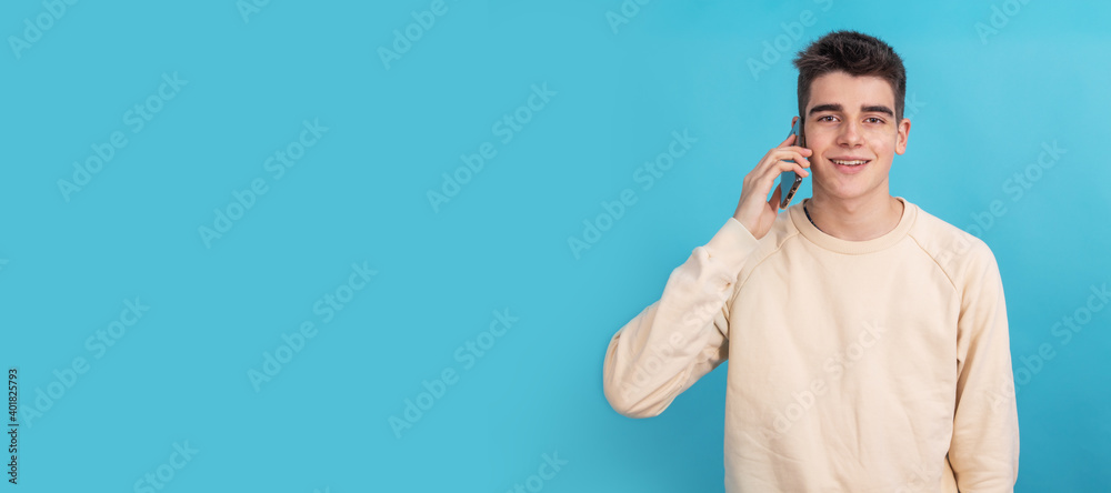 Fototapeta premium smiling teenager boy or student with mobile phone isolated on background