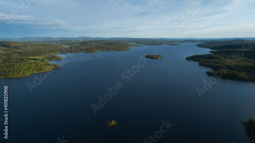 Aerial vibrant summer view of an island and skerries in the lake Inari, scandinavian landscape, shot from drone